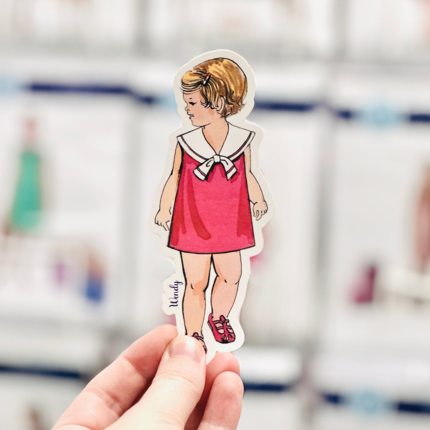 Wendy watercolor sticker of a girl in a red sailor dress and red shoes.