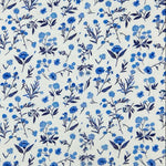 White cotton corduroy fabric with scattered blue floral motifs in various shades