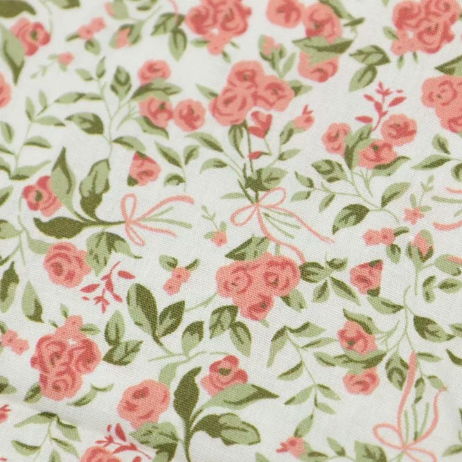 White cotton poplin fabric with pink rose bouquets, green leaves, and ribbon bows print