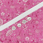 Pink floral cotton fabric with white stripe and four pearlescent white buttons