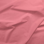 Solid petunia pink cotton fabric with soft drape and subtle folds