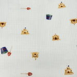 White seersucker fabric with small sandcastles, blue buckets, and red shovels pattern