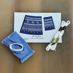 Let It Snow smocking kit with blue pleated fabric, white DMC floss, and pattern graph