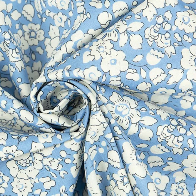 Light blue poplin fabric with white daisy floral print, twisted into a spiral fold