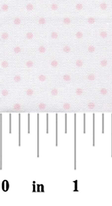 White fabric with small evenly spaced baby pink polka dots, shown with ruler