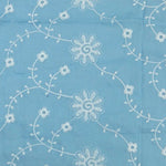 Sky blue cotton eyelet fabric with white embroidered daisy vine floral pattern