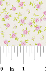 Pink rose floral print fabric swatch with green leaves on cream background with ruler