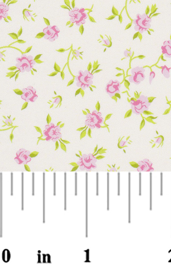 Pink rose floral print fabric swatch with green leaves on cream background with ruler