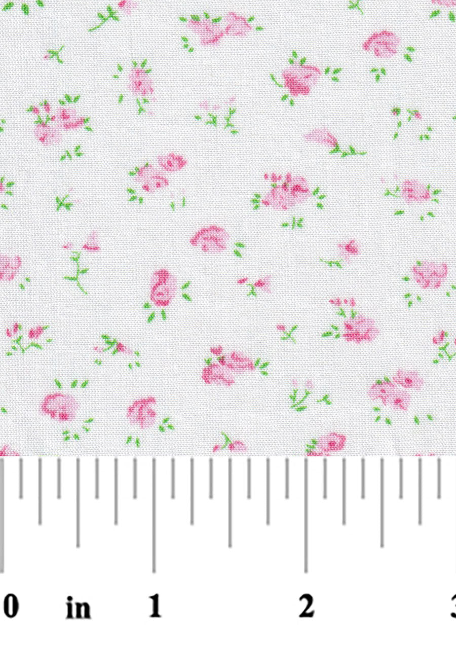 White cotton fabric with scattered small pink roses and green leaves pattern