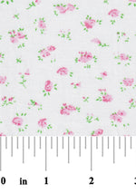 White cotton fabric with scattered small pink roses and green leaves pattern