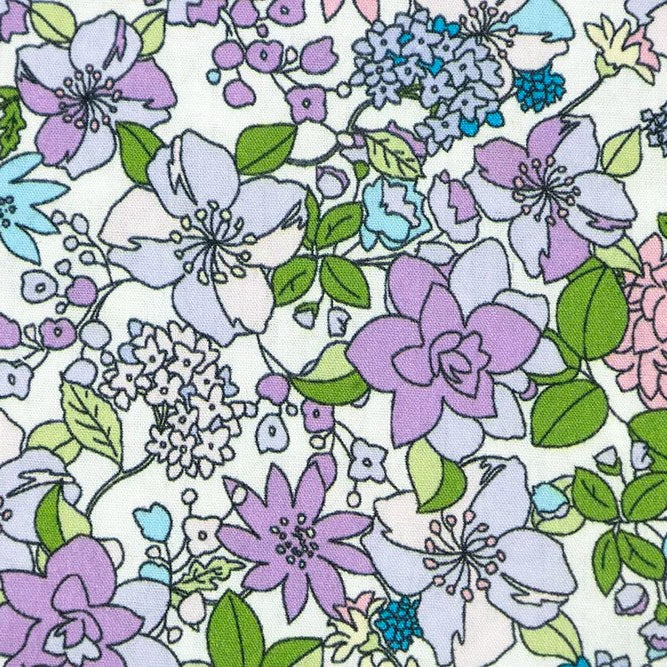 Cotton poplin fabric with purple, blue, and pink floral print on white background