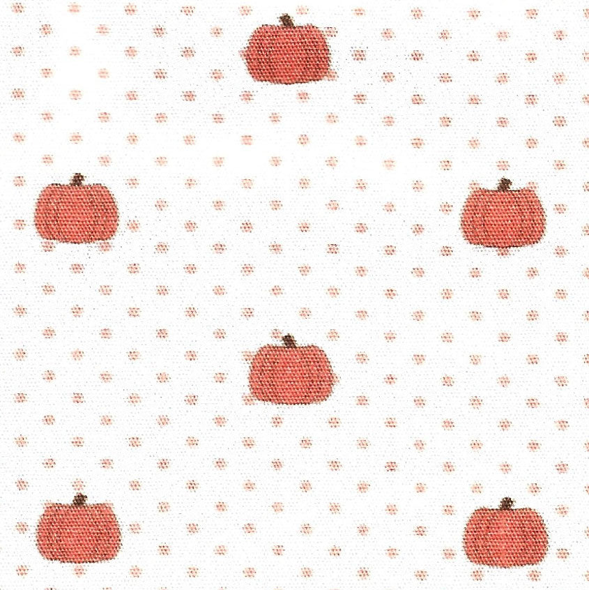 White cotton fabric with orange pumpkins and small orange polka dots scattered throughout