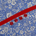 Blue floral fabric with red grosgrain ribbon and four red buttons
