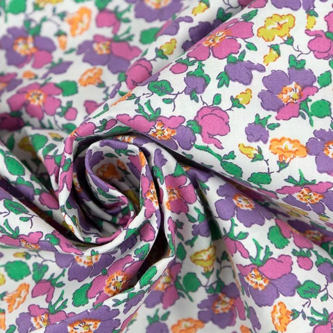 White cotton poplin fabric with purple, pink, orange, and green floral print