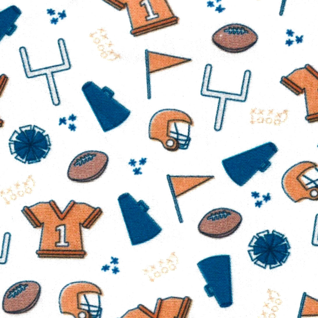 White fabric with orange and navy blue football helmets, jerseys, balls, and goal posts