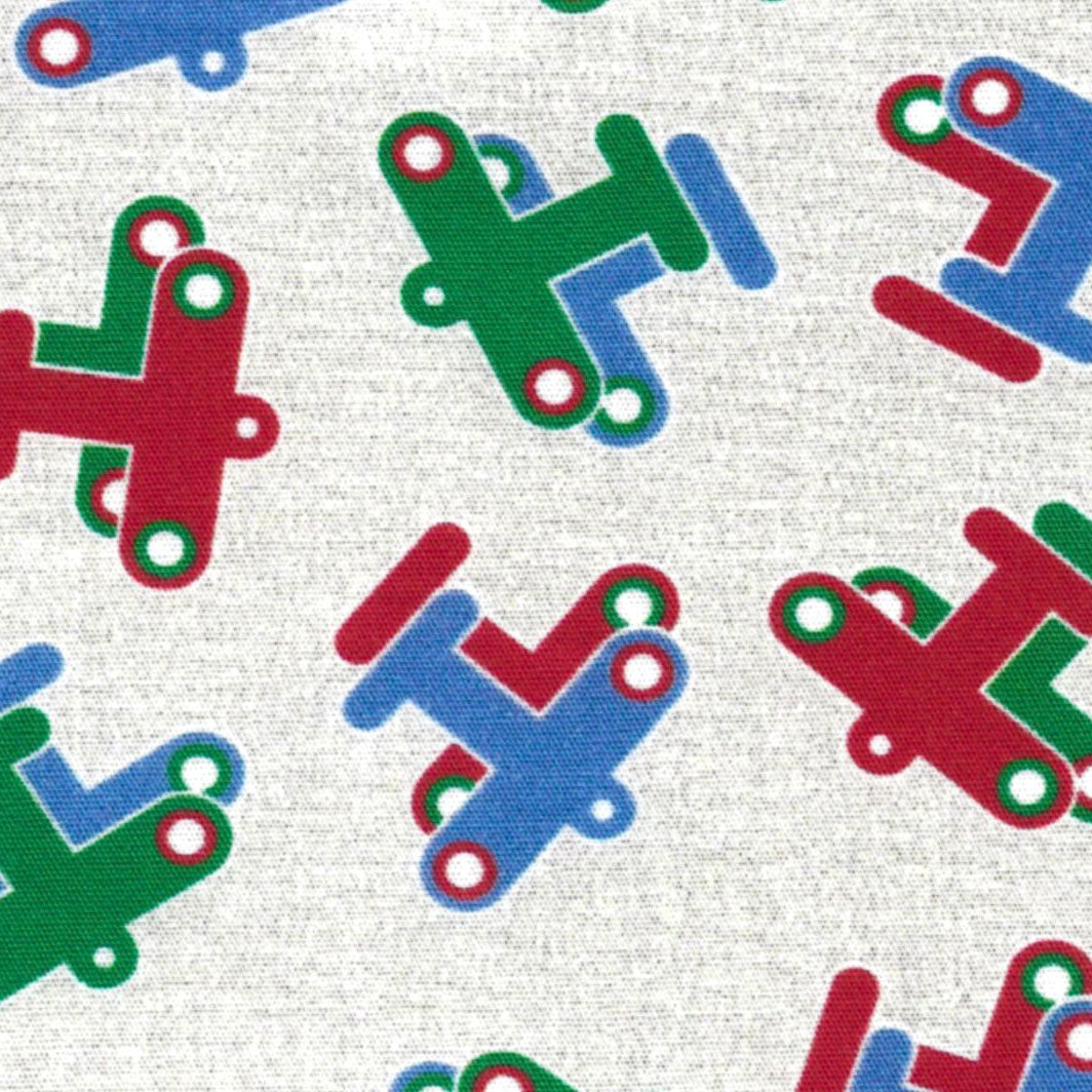White fabric with tossed red, green, and blue toy airplane prints