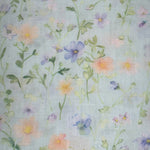 Seafoam fabric with soft watercolor wildflowers in peach, purple, and yellow with green stems