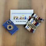 Nativity smocking kit with blue fabric, DMC floss skeins, and pattern card