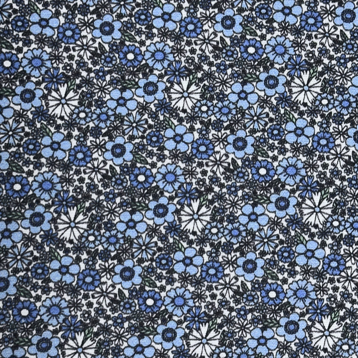 Cornflower Fields fabric with dense blue floral print on white cotton by Fabric Finders