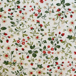 Cream cotton fabric with red strawberries, tiny red roses, and white flowers on green vines