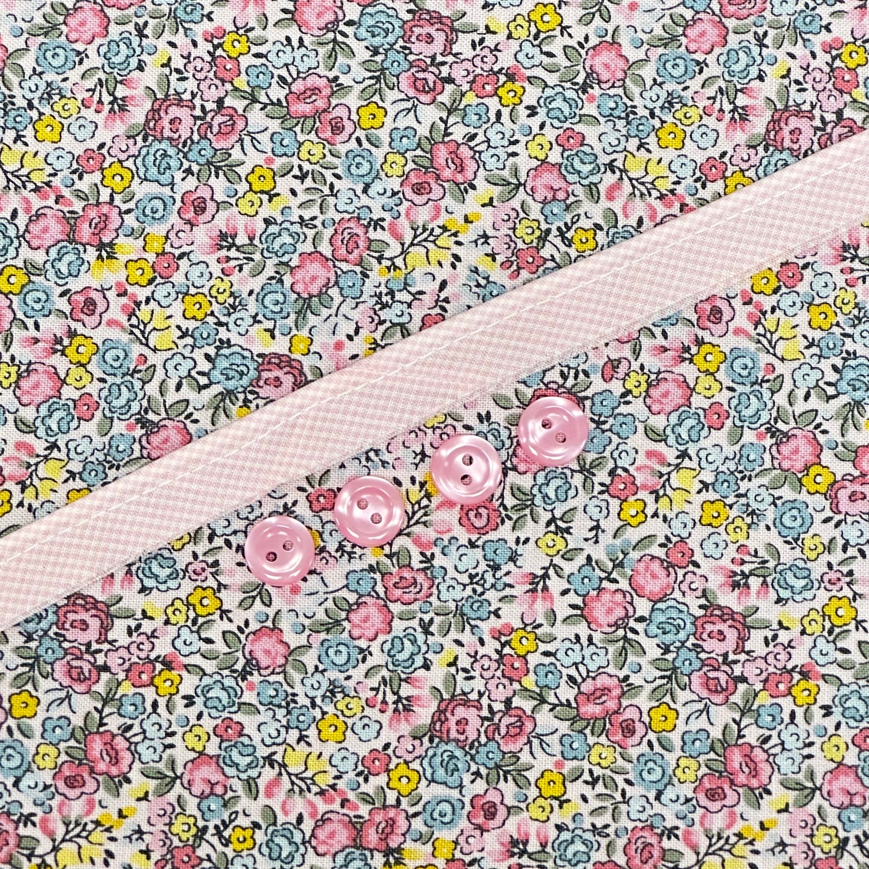 Floral cotton fabric with pink ditsy flowers and pink buttons on placket