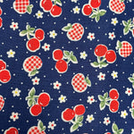 Navy blue quilting cotton fabric with red cherries, gingham apples, and white flowers