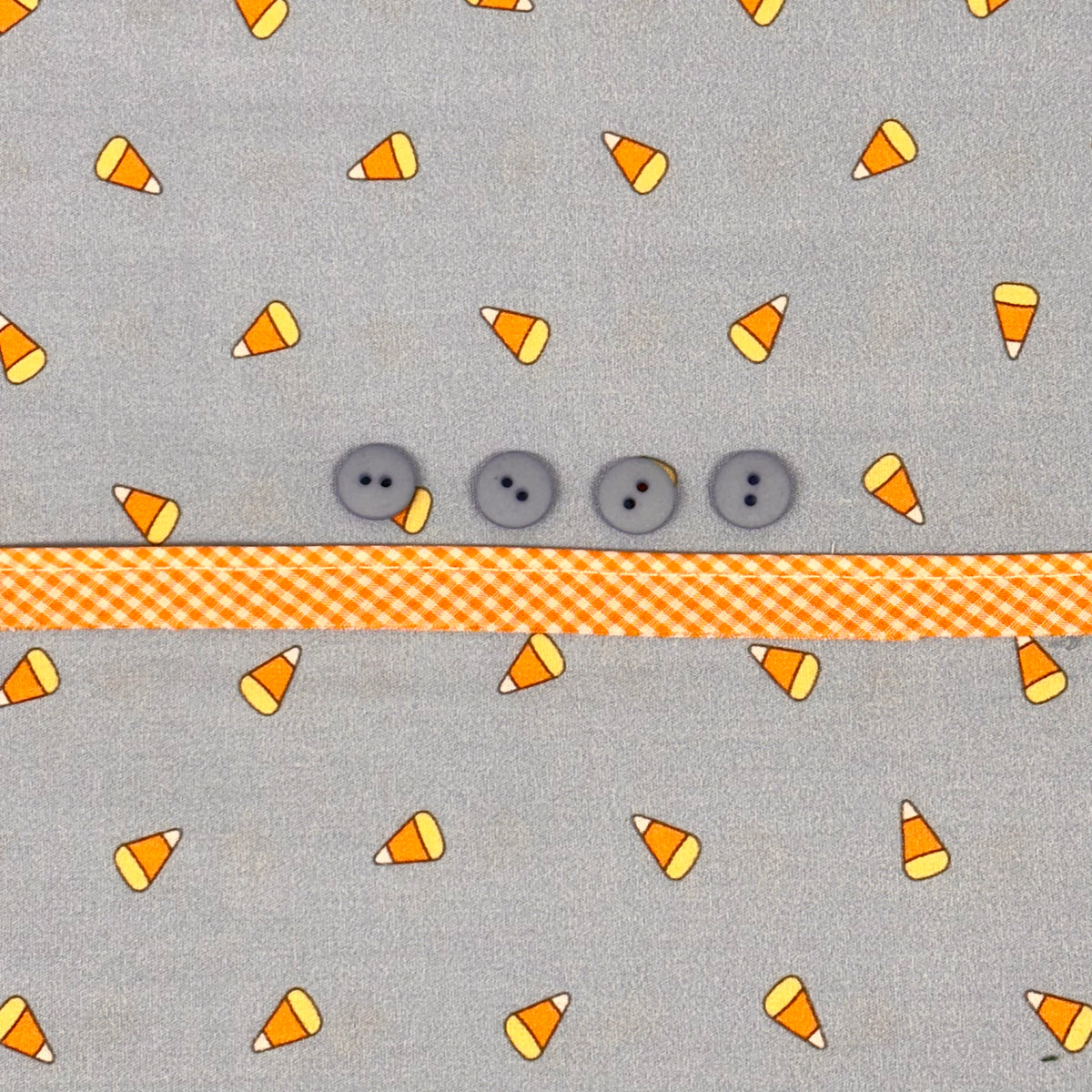 Gray candy corn print fabric with gray buttons and orange gingham ribbon trim