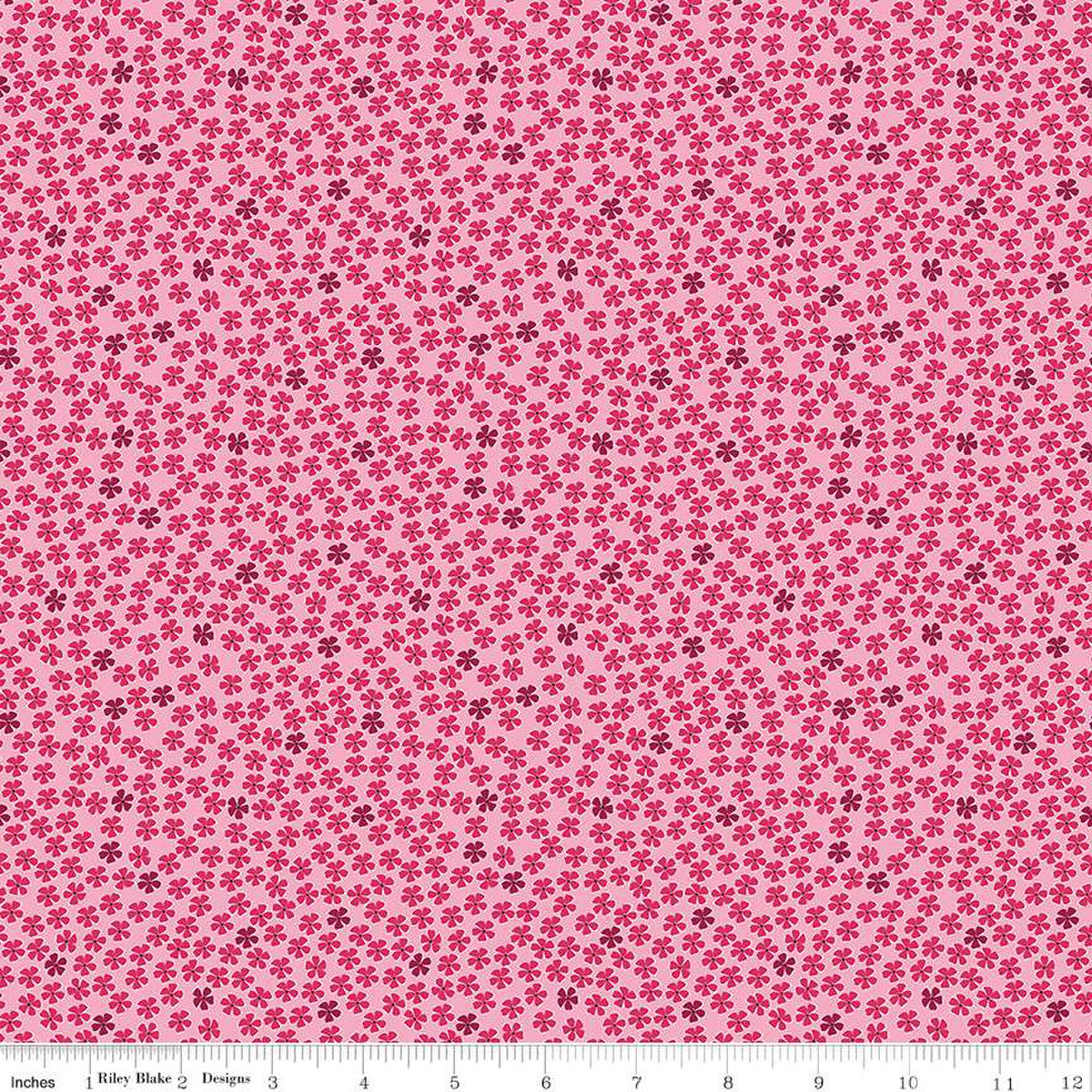 Pink cotton fabric with scattered small red and burgundy floral ditsy print pattern