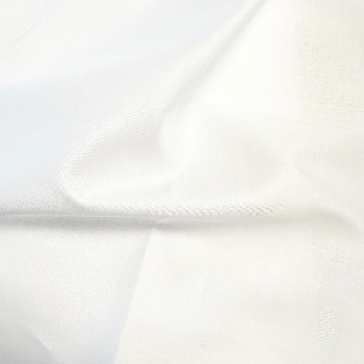 Soft white Swiss Batiste Nelona fabric with gentle folds showing smooth texture
