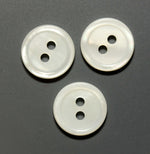 Three round white mother of pearl buttons with two holes and raised rim