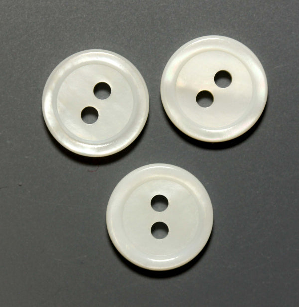 Three round white mother of pearl buttons with two holes and raised rim
