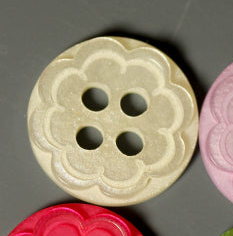Cream scalloped flower plastic button with four holes and floral edge detail