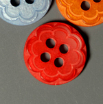 Scalloped flower plastic buttons in red, blue, and orange with four holes