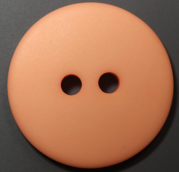 Matte peach round plastic button with two holes, dome-shaped profile