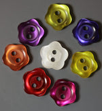 Eight shiny flower-shaped plastic buttons in assorted colors including purple, red, pink, and yellow