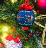 Navy smocked Christmas ornament with Santa sleigh design, red ribbon bow, on tree