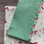 Christmas pillowcase kit with green gingham, plaid, and reindeer snowflake print fabrics