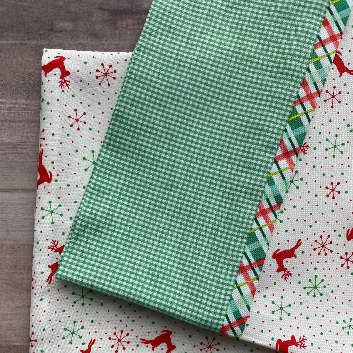 Christmas pillowcase kit with green gingham, plaid, and reindeer snowflake print fabrics