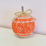 Orange and white smocked fabric pumpkin with twine bow and stem