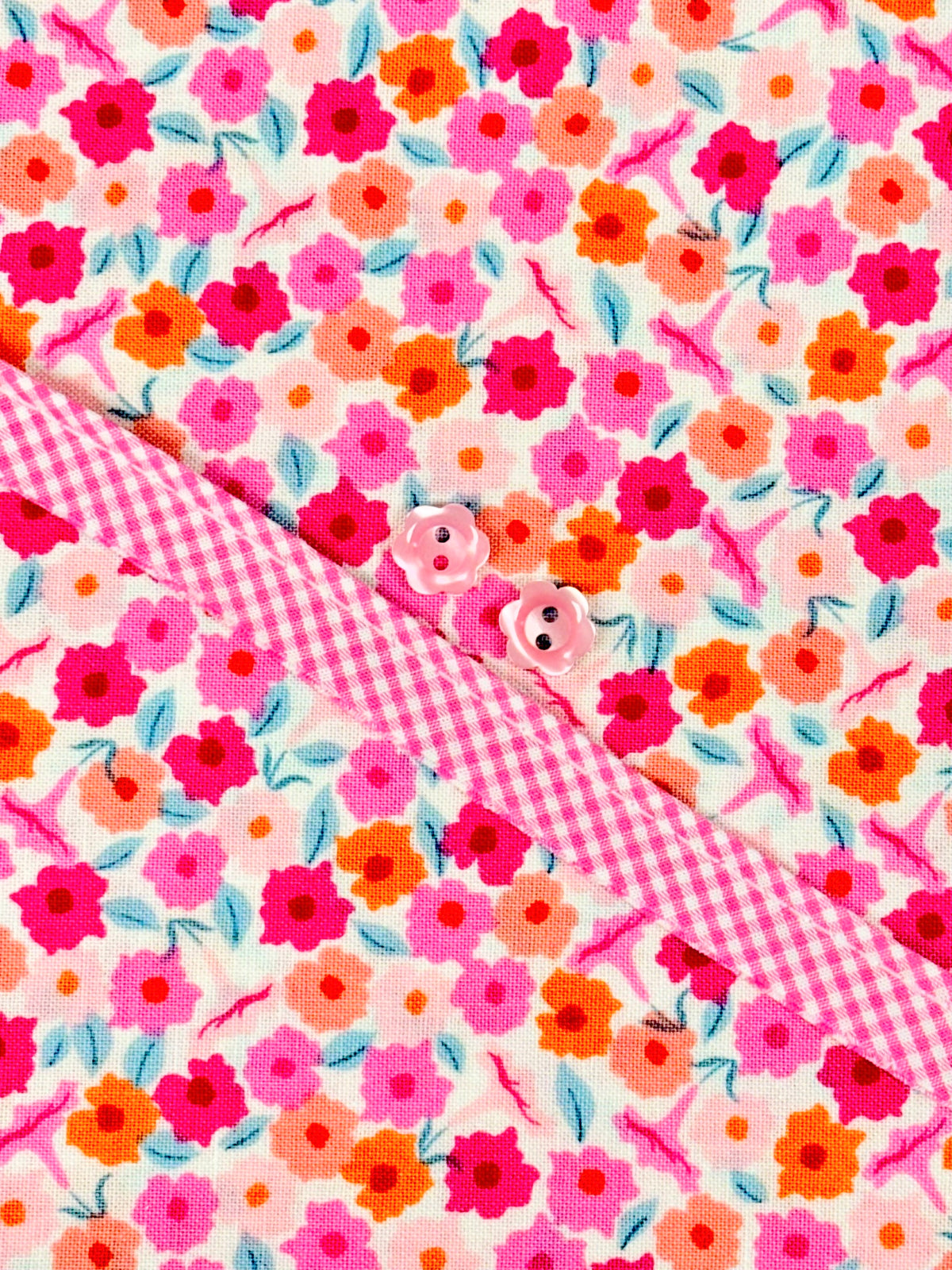Floral print fabric with pink gingham collar and pink flower buttons