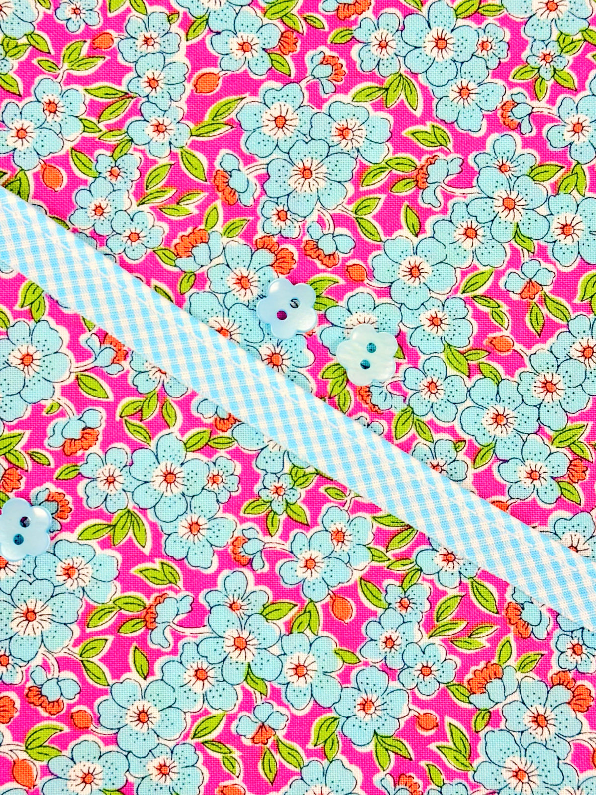 Louise Dress Kit with pink floral fabric, blue gingham trim, and light blue buttons