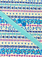Louise Dress Kit with floral stripe fabric in blue and pink, teal ribbon, and flower buttons