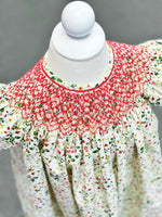 White floral bishop dress with red smocked yoke on child mannequin