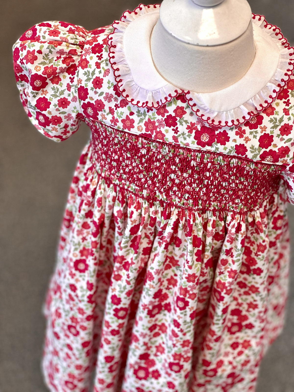 Red floral smocked girls dress with white Peter Pan collar and puff sleeves