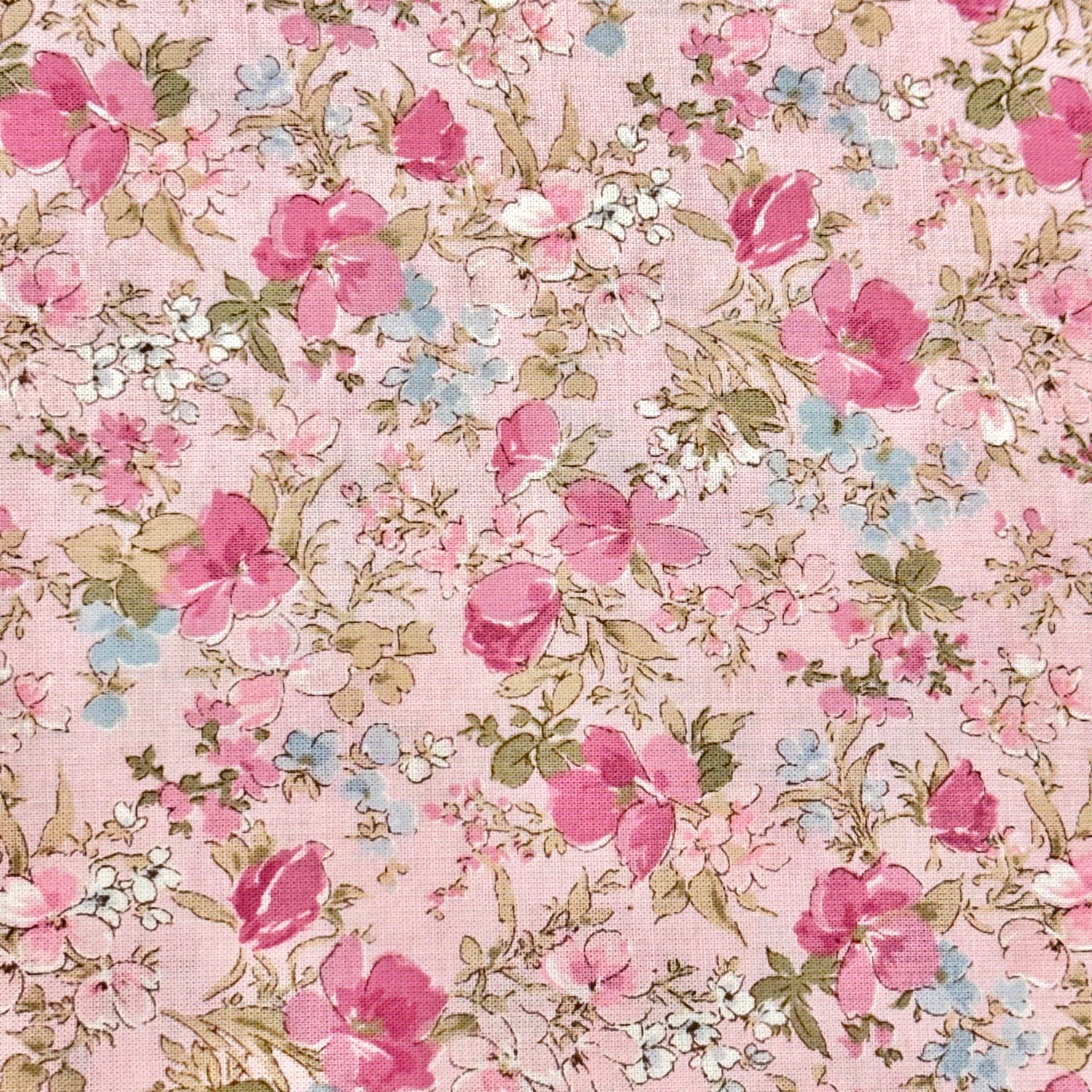 Pink cotton lawn fabric with scattered pink roses, white blooms, and sage green leaves
