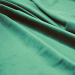 Draped teal velveteen fabric with soft folds showing smooth, plush texture