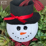 Smocked white snowman ornament with black felt hat, red ribbon bow, and buffalo plaid scarf