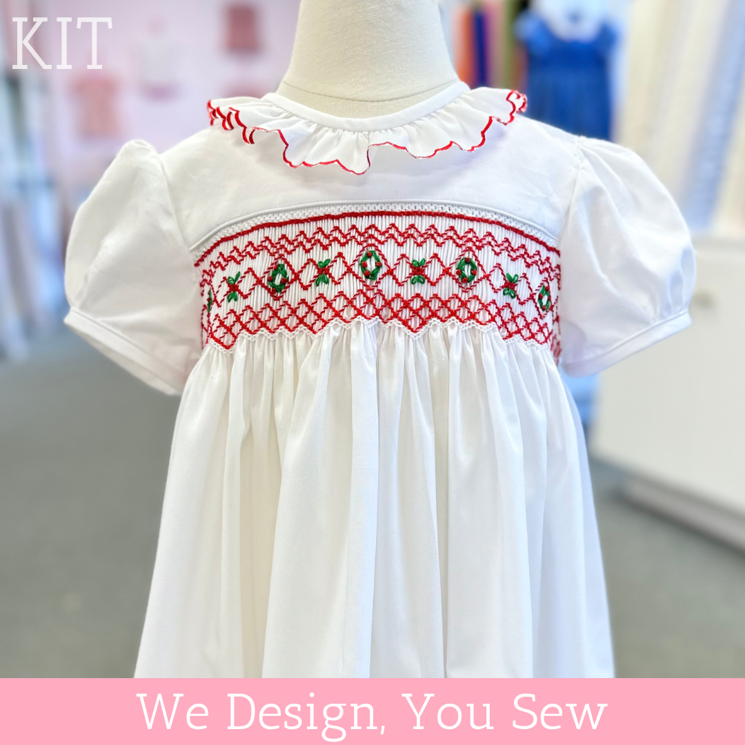 White child's bishop dress with red and green smocked Christmas holly bodice and ruffled collar