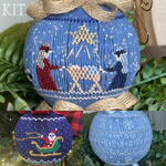 Smocked Christmas ornament kit featuring nativity scene, Santa sleigh, and star lattice designs