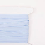 Light blue piping trim wound on a white cardboard card, showing stitched edge detail
